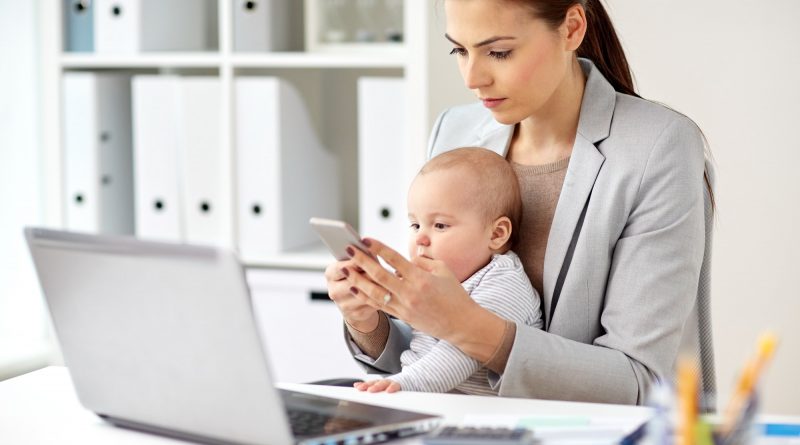 businesswoman with baby and smartphone at office