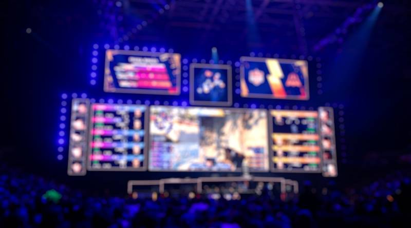 Blurred background of an esports event - Big illuminated main stage of a computer games tournament