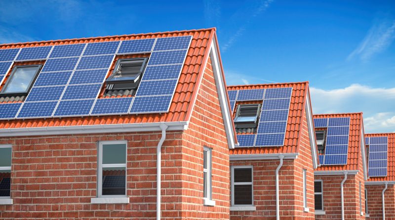 Row of house with solar panels on roof on blue sky background.